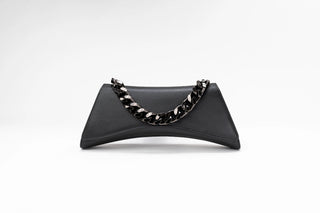 A black leather clutch bag with a curved silhouette and a chunky silver chain handle, photographed against a clean white studio background.