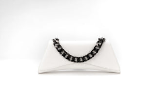 A white envelope-style clutch purse with a prominent black chain-link