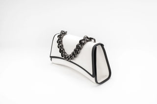 A white leather shoulder bag with black trim and a chunky black chain strap