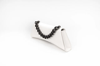 A white leather clutch bag with a black chain handle, displayed on a white background.