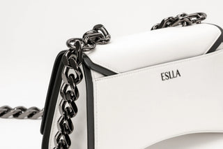 White leather shoulder bag with black trim and a chunky black chain strap