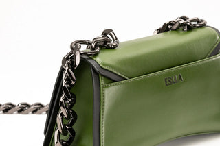 Close-up of an olive green leather handbag with black trim and a chunky silver chain strap.