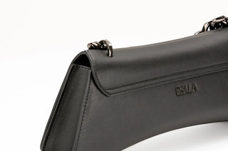 Close-up of a black leather shoulder bag with a chain strap and a debossed ESULA logo on the front flap