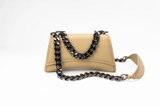 A beige leather handbag with a structured, curved silhouette, featuring a flap top with black hardware 2