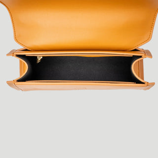 Top-down view of a structured mustard yellow leather clutch bag with an open flap