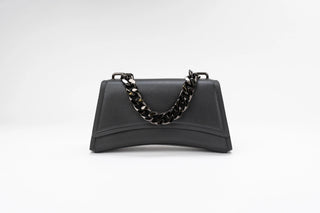 A black leather handbag with a curved bottom edge and a chunky black chain strap