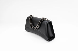 A black leather shoulder bag with a curved silhouette and a chunky dark metal chain strap