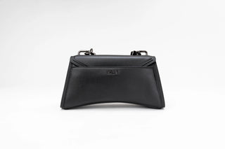 A black leather handbag with a structured envelope-style flap and a curved bottom edge