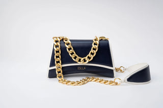 A structured navy blue and white handbag with a chunky gold chain strap, displayed on a clean white background.