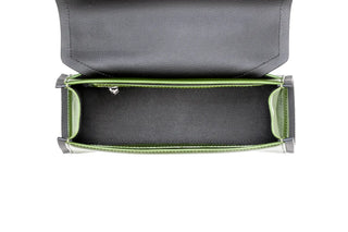 Top-down view of an open black leather clutch or wallet with a bright green interior lining and silver-tone