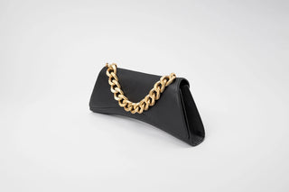 A black leather clutch bag with a prominent gold-tone chain link handle.