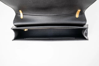 A black leather clutch bag with a distinctive curved bottom edge.